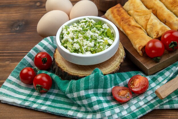 vista frontal, pastéis de verduras fritas com tomates vermelhos em fundo marrom