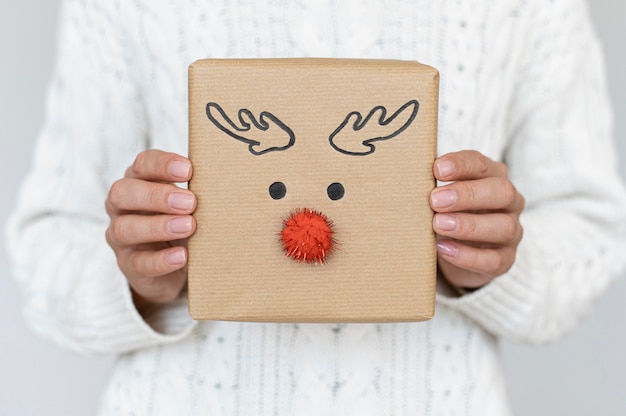 Foto vista frontal de la persona con lindo reno decorado regalo de navidad