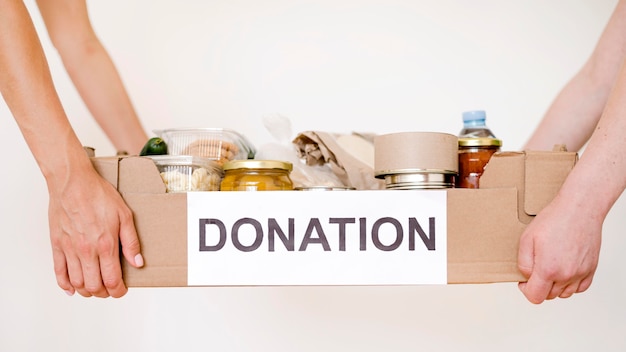 Foto vista frontal de personas con caja de donación con comida