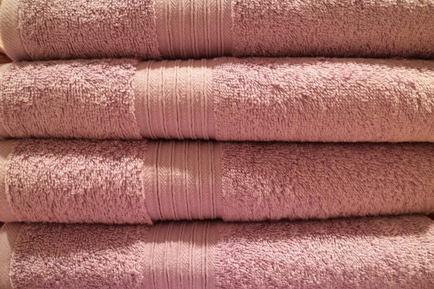 Vista frontal de la pila de toallas de baño esponjosas de color rosa dobladas
