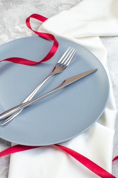 Vista frontal de la placa azul con un tenedor y un cuchillo en la superficie de la luz cocina señoras horizontal comida comida vidrio feminidad familiar