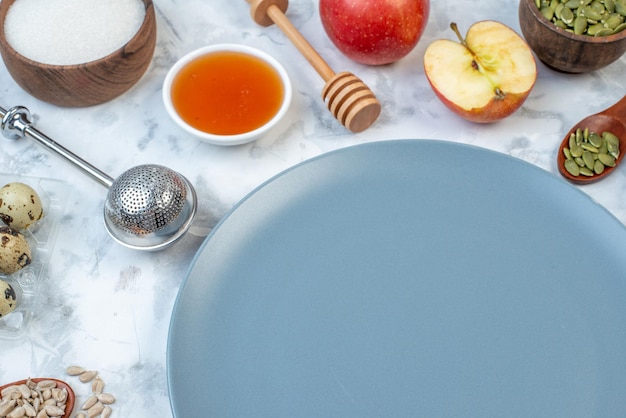 Vista frontal del plato vacío y los ingredientes para los alimentos saludables en la mesa azul blanca