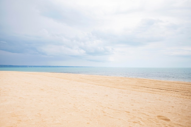 Foto vista frontal de la playa con arena y nubes