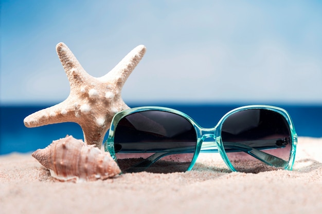 Foto vista frontal de la playa con gafas de sol y estrellas de mar