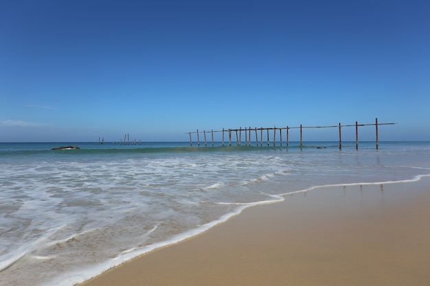 La vista frontal a la playa ofrece vistas al antiguo puente de madera en verano, ideal para practicar surf