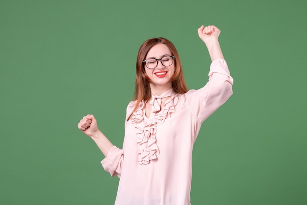 Vista frontal professora de blusa rosa em fundo verde livro estudante trabalho escola faculdade jovem lição cor trabalho biblioteca mulher