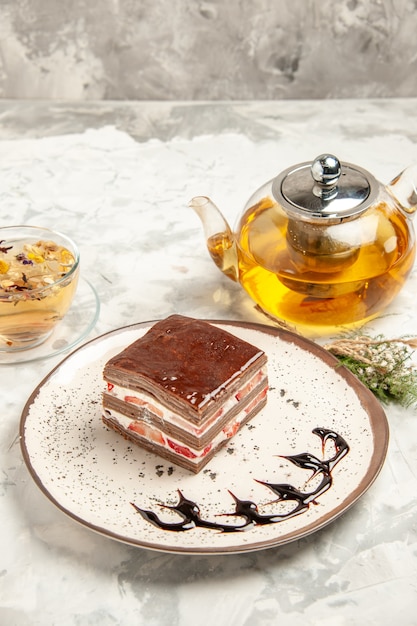Vista frontal rebanada de pastel delicioso dentro de la placa sobre el fondo blanco postre dulce galleta helado pastel galleta tarta de té