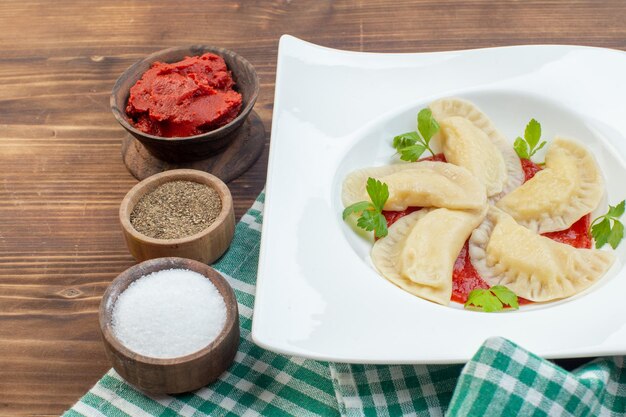 vista frontal saborosos bolos quentes de batata com pasta de tomate e temperos em fundo marrom cozinhando assar cozinha massa serviço massa