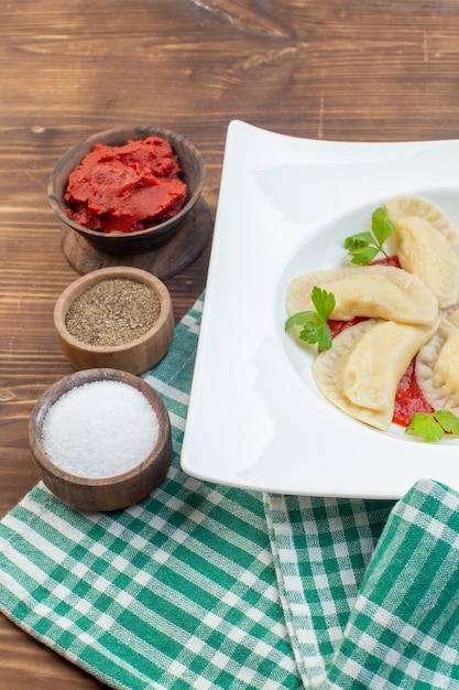 vista frontal saborosos bolos quentes de batata com pasta de tomate e temperos em fundo marrom cozinhando assar cozinha restaurante serviço de massas