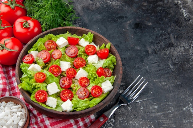 Vista frontal sabrosa ensalada de verduras con tomates con queso en rodajas y condimentos sobre fondo oscuro comida comida color almuerzo salud