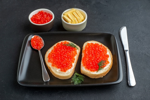 Vista frontal sabrosos sándwiches de caviar placa interior sobre fondo oscuro bocadillo plato de pescado tostada comida mariscos cena comida desayuno