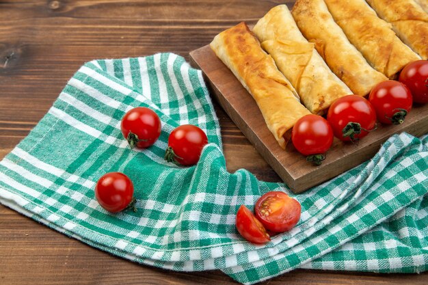 vista frontal tortas de verduras fritas com tomates vermelhos em fundo marrom torta pastelaria carne assar o jantar