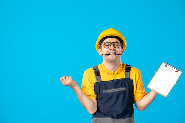 Vista frontal del trabajador de sexo masculino en uniforme amarillo con el bloc de notas en sus manos en azul