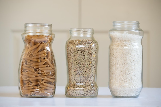 Vista frontal de tres frascos de vidrio con productos alimenticios