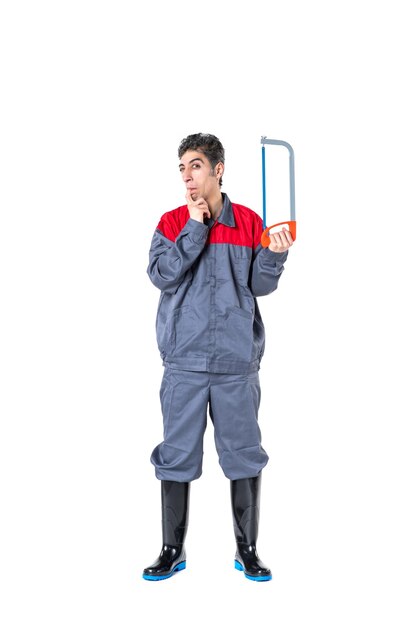 Vista frontal del varón joven en uniforme con sierra para metales sobre fondo blanco trabajo cuchillo foto arquitectura edificios trabajador trabajo duro