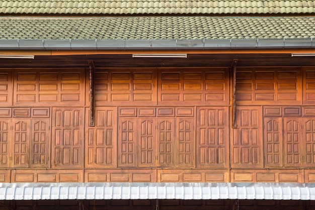 Vista frontal de la ventana de madera con tejas, fachada de casa de madera