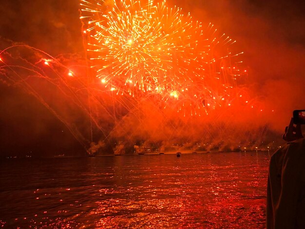 Vista de fuegos artificiales sobre el río por la noche