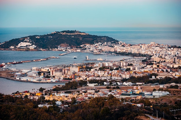 Vista general de la bahía de Ceuta al atardecer con el monte Hacho en el fondo mientras un ferry entra