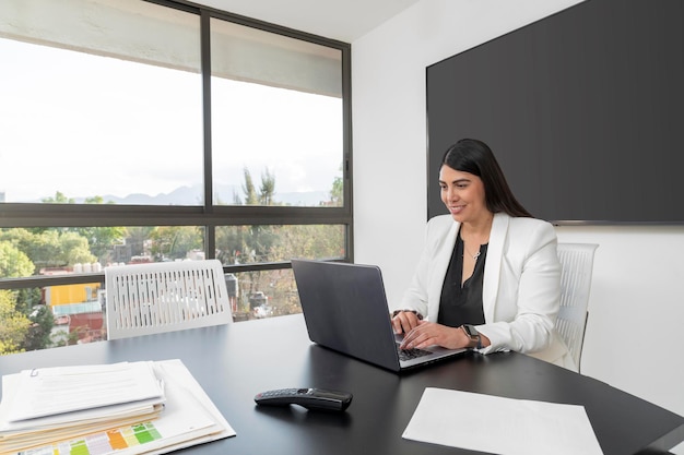 Vista general de la mujer ejecutiva que trabaja en su oficina mirando hacia afuera Mujer feliz trabajando en la oficina