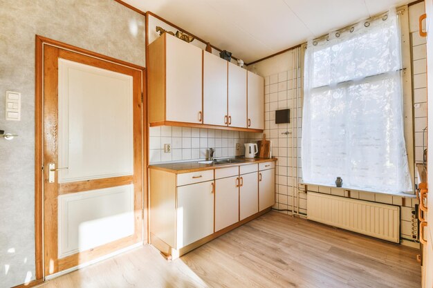 Vista general de una pequeña cocina de esquina en el suelo de parquet de una casa moderna