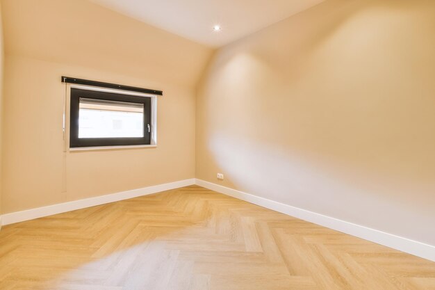 Vista geral de uma sala vazia e brilhante com janelas acima de um piso em parquet de uma casa moderna