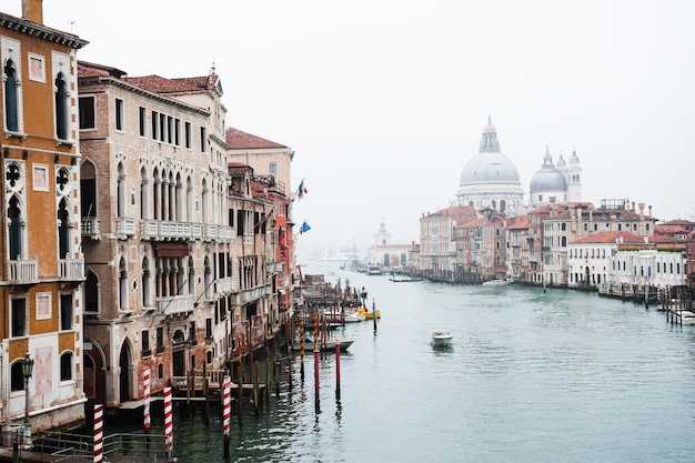 Vista del Gran Canal y la Basílica de Santa Maria della Salute en Venecia, Italia. Día nublado brumoso. Destino turístico famoso. Concepto de viajes y vacaciones.