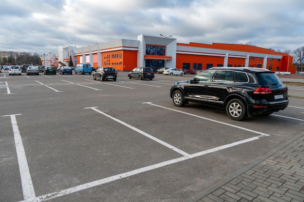 Foto vista de un gran estacionamiento en el fondo de un edificio rojo estacionamiento vacío muchos estacionamientos gran estacionamiento al lado del centro comercial