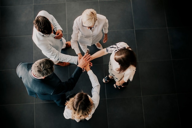 Foto vista en grupo de empresarios tomados de la mano juntos