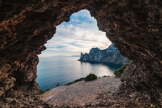 Vista desde la gruta rocosa a la bahía del mar al atardecer