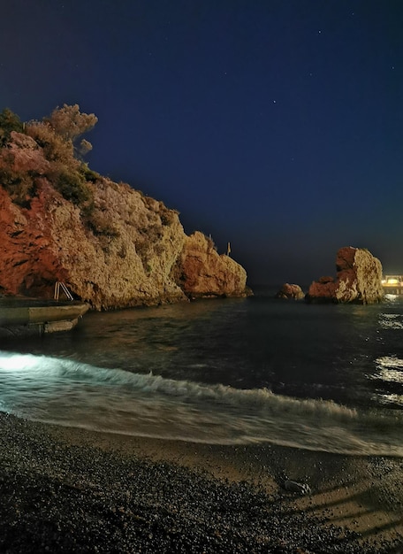 Vista de la hermosa costa rocosa por la noche con olas azules