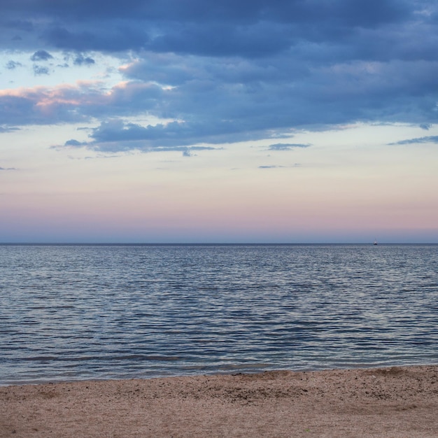 Vista de hermosas nubes en la noche al atardecer desde la orilla del mar