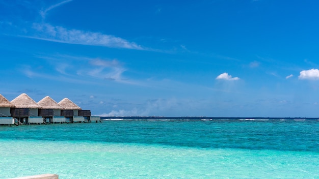 Vista del hermoso agua del océano azul y bungalows en Maldivas.