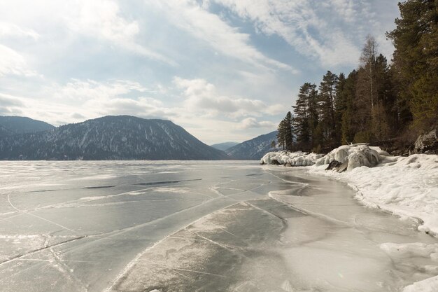 Foto vista de hermosos dibujos en el hielo desde las grietas en la superficie del lago teletskoye en el invierno de rusia