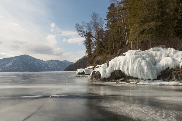 Foto vista de hermosos dibujos en el hielo desde las grietas en la superficie del lago teletskoye en invierno rusia