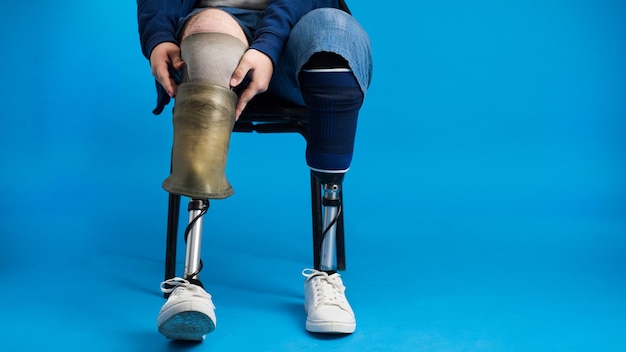 Foto vista de un hombre con piernas ortopédicas y zapatillas blancas quitar la prótesis