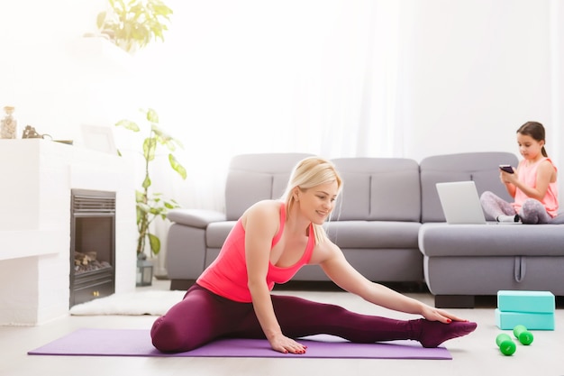 Vista horizontal de una mujer haciendo yoga en casa