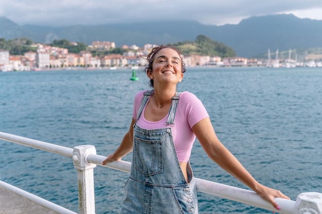 Vista horizontal de la mujer que viaja sola en verano. Mujer caucásica de sonrisa blanca de vacaciones en Asturias. Destino de viaje en España y concepto de verano.