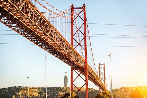 La vista horizontal sobre el puente 25 de abril durante la puesta de sol en la ciudad de Lisboa, Portugal.