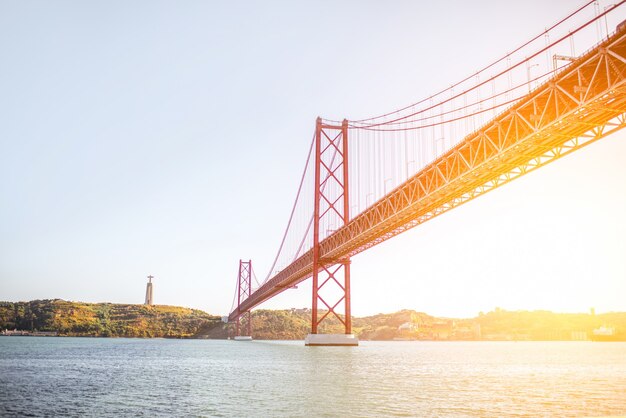 La vista horizontal sobre el puente 25 de abril durante la puesta de sol en la ciudad de Lisboa, Portugal.