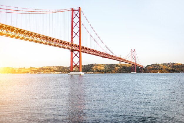 La vista horizontal sobre el puente 25 de abril durante la puesta de sol en la ciudad de Lisboa, Portugal.