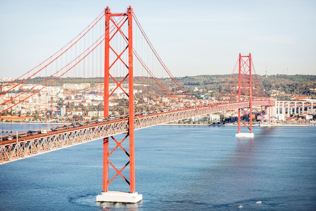 La vista horizontal sobre el río Tajo y el famoso puente 25 de abril durante la luz de la mañana en la ciudad de Lisboa, Portugal.