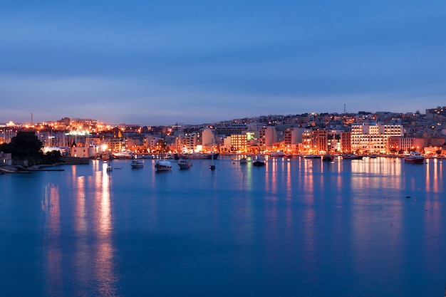 Vista del horizonte de Valletta frente al mar como se ve desde Sliema, Malta. Edificios históricos iluminados después del atardecer.