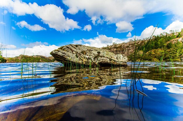 Foto vista idílica de rocha e céu refletido na água do lago