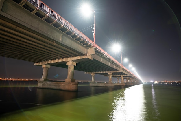 Vista inferior de uma bela e longa ponte sobre o grande e belo rio Dnieper