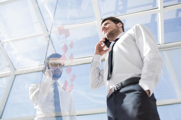 Vista inferior del hombre de negocios hablando por móvil en la oficina concepto de negocio