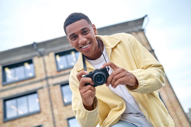 Vista inferior del hombre sonriendo a la cámara