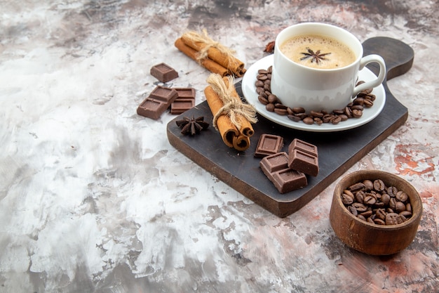 vista inferior xícara de café com grãos de café torrados de anis no pires chocolate paus de canela anis na mesa espaço livre