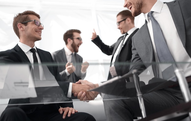 Vista inferiorempresários apertando as mãos na mesa de negociação