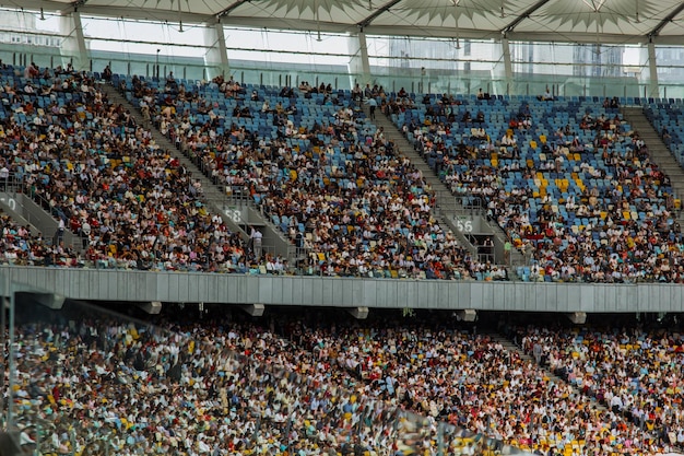 Foto vista interior del estadio de fútbol campo de fútbol vacío se encuentra una multitud de aficionados un techo contra el cielo