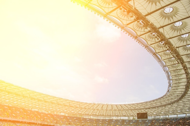 Vista interior del estadio de fútbol campo de fútbol vacío se encuentra una multitud de aficionados un techo contra el cielo